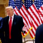 En se cachant et en faisant un clin d'œil, Donald Trump apprend que son procès pénal débutera le mois prochain