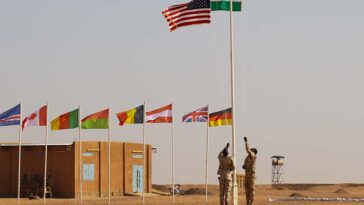 cc US Africa Command, modified, https://flickr.com/photos/africom/40694842964/in/photolist-2634Fmp-DzoqrC-2514H2w-24ZvUWZ-2635Vfe-23ADbY5-25YmSTJ-23jUwH1-23ApooY-JdLDLy-23AprEN-25gj9X1-26hMPUj-2669FND-JdKmPE-23ApoRb-HX3MrY-24X75eq-26hNdn5-JdKQnW-Gr4Cjz-24X5W4u-26mqApR-24X5kdC-253ag8o-23kigc5-23AAppU-24LcCTR-26mqBQg-268hVfF-23ApqVw-26hLxF9-HX3K6f-2jma2bd-HX3LGb-253abjL-23jUwas-HZrvhq-23yvi1U-24LcJTX-268hSPD-26mqvwK-24X6BAA-24LcrbT-26fF6R5-268hPm6-268huuZ-23nrCaE-2epyJUw Nigerien and American flags are raised at the opening ceremony of Flintlock 2018 at Agadez, Niger on 11 April, 2018. Flintlock is U.S. Africa Command