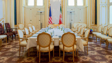cc US Department of State, Wikicommons, A view of the Blue Salon at the Palais Coburg hotel in Vienna, Austria, the 19th-century, Neoclassical former palace for Prince Ferdinand of Saxe-Coburg, where most of the bilateral meetings between the United States, other P5+1 countries, European Union, and Iran took place, as well as one-on-one meetings between Secretary Kerry and Iranian Foreign Minister Javad Zarif. Secretary Kerry sat on the left side of the table, third chair from the bottom, and Minister Zarif sat directly across on the right side of the table. [State Department photo/ Public Domain]