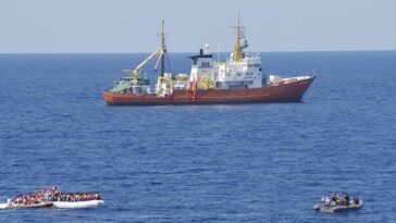 cc Flickr, modified, Commander, U.S. Naval For, 160729-N-ZE250-283 MEDITERRANEAN SEA (July 29, 2016) - Sailors assigned to USS Carney (DDG 64) provide security while members of the SOS Mediterranee ship MS Aquarius rescue migrants on a small craft in the Mediterranean Sea July 29, 2016. Carney, an Arleigh Burke-class guided-missile destroyer, forward deployed to Rota, Spain, is conducting a routine patrol in the U.S. 6th fleet area of operations in support of U.S. national security interests in Europe. (U.S. Navy photo by Mass Communication Specialist 3rd Class Weston Jones/Released)
