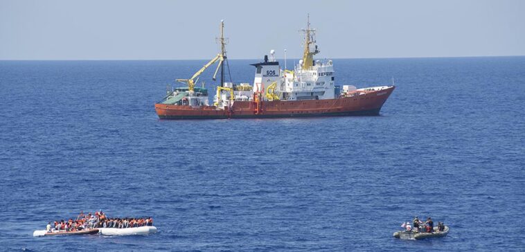 cc Flickr, modified, Commander, U.S. Naval For, 160729-N-ZE250-283 MEDITERRANEAN SEA (July 29, 2016) - Sailors assigned to USS Carney (DDG 64) provide security while members of the SOS Mediterranee ship MS Aquarius rescue migrants on a small craft in the Mediterranean Sea July 29, 2016. Carney, an Arleigh Burke-class guided-missile destroyer, forward deployed to Rota, Spain, is conducting a routine patrol in the U.S. 6th fleet area of operations in support of U.S. national security interests in Europe. (U.S. Navy photo by Mass Communication Specialist 3rd Class Weston Jones/Released)