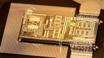 Gros plan d'une puce développée par l'équipe de Bhavin Shastri. La couleur de la puce est l'or.