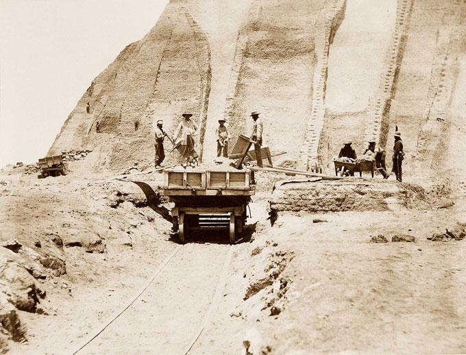 Cette image de 1865 montre des ouvriers en train de creuser une montagne de crottes d'oiseaux. Certains poussent des brouettes pleines et d'autres vident les brouettes dans un wagon qui se trouve sur des rails qui s'éloignent du tas de fumier.