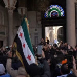 cc VOA, modified, https://commons.wikimedia.org/w/index.php?title=Special:Search&limit=500&offset=0&ns0=1&ns6=1&ns12=1&ns14=1&ns100=1&ns106=1&sort=last_edit_desc&search=syria+assad+filetype%3Abitmap&sort=last_edit_desc&advancedSearch-current={%22fields%22:{%22filetype%22:%22bitmap%22}}#/media/File:Syrians_celebrate_the_fall_of_Assad_at_the_Umayyad_mosque,_14_December_2024.jpg