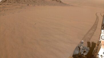 Une pente sablonneuse avec une partie d'un véhicule robot est représentée