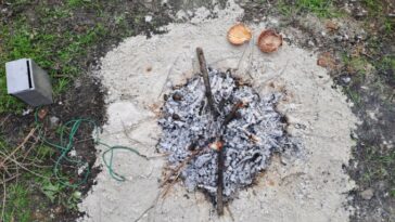 Image aérienne d’un cercle de sable avec une zone en feu au milieu.