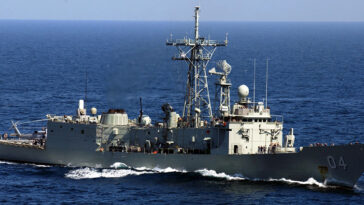 cc US Navy, modified, https://en.m.wikipedia.org/wiki/File:HMAS_Darwin_F-04.jpg / Persian Gulf (Mar. 15, 2005) — The Royal Australian Navy frigate HMAS Darwin (FFG 04) underway in the waters of the Persian Gulf alongside the Nimitz-class aircraft carrier USS Harry S. Truman (CVN 75). Darwin is a long-range escort with roles including area air defense, anti-submarine warfare, surveillance, reconnaissance and interdiction. She can counter simultaneous threats from the air, surface and sub-surface. The Truman Carrier Strike Group is on a regularly scheduled deployment in support of the Global War on Terrorism.