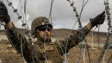 cc US Department of Defense, modified, https://flickr.com/photos/39955793@N07/45440230804/in/photolist-2cep4vf-WdexVB-gGm4hp-6ZnFgM-7biJPt-QTH5Ue-7bnhnm-WaNfG1-93eidn-NBDjfT-uoPJaw-SfpYh4-z6mvgr-7bnuQJ-ehZP6L-PK41as-93eik2-79WrQP-nQp4WW-4eAu2j-2bNC1tA-93hrk7-7a1ma3-2qbmnh1-7a1pkS-5AUzx8-35Fe3h-aeyfR9-9EbQY5-95tfCs-237UqV5-yNKiFd-68EbC1-JG9PU9-5GJRXm-6KSBK1-9xri1L-pRjuYG-c2me4h-95qcAv-c2mdMJ-JGf4Ez-KcyqdL-KcyqGm-Kcys6o-pNoMgT-2auw51X-quzxgD-6ZnDHn-quzvWz U.S. Marine Corps Lance Cpl. Victor Vargas, a combat engineer with 7th Engineer Support Battalion, Special Purpose Marine Air-Ground Task Force 7, emplaces concertina wire at the California-Mexico Border, Nov. 30, 2018. U.S. Northern Command is providing military support to the Department of Homeland Security and U.S. Customs and Border Protection to secure the Southern border of the United States. (U.S. Marine Corps photo by Lance Cpl. Brendan Mullin)