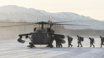 cc US National Guard, modified, https://flickr.com/photos/thenationalguard/52559487300/in/photolist-2o5v7qU-25VYCJW-2iJ7Ffx-Hy4aDd-2mTKD6e-2gUtwwc-28zWwXY-28zWwPw-28J3koK-HVtnZ7-28DB9wj-HYvNcT-K1sqUa-25Y97M9-27CD5Bh-27CD4oL-28JaYi2-H3JUUM-2ixygcL-25UjHpE-Be4QKA-2htFNZM-25Y1p9U-LAf4aG-H3E2ub-2pnWC3P-KEvGen-HVtmBY-H3E1ah-2nbfKEa-2ibDYCm-HS91Lr-2qAAmQK-2g6hjTs-H3JWKR-HYvNLZ-28EFWvD-2nYwmUt-2ocyjzK-2hsb7g1-AmT2iV-AkwmUR-2c34dj1-EKRiat-2n7sJxT-KcNhtE-dQJmPf-2ockkKg-y8T1G9-KcNfFm, University of Alaska Army ROTC cadets board an Alaska Army National Guard UH-60L Black Hawk helicopter, assigned to the 1-207th Aviation Regiment, during an air assault training event at Joint Base Elmendorf-Richardson, Alaska, Dec. 2, 2022. Following the tactical insertion, the Seawolf Detachment cadets maneuvered across snow-covered terrain, assaulted opposition forces, secured their objective, and concluded with an air exfiltration. The AKARNG’s General Support Aviation Battalion routinely trains with all branches of the military as well as civilian agencies to hone its operational interoperability and maintain readiness for a wide range of state and federal missions. (U.S. Air Force photo by Alejandro Peña)