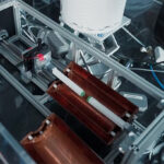 Un appareil expérimental avec deux carrés verts montés sur les bras sur le point de toucher.