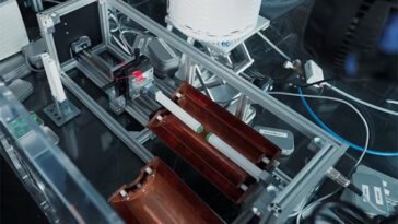 Un appareil expérimental avec deux carrés verts montés sur les bras sur le point de toucher.