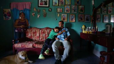 YARUMAL, - AUGUST 18 - Alirio sits in his living room with his son Alexis, 6, snuggles in and his wife Marta. Alirio, 42, is a coffee farmer who is also a participant in the University of Antioquia study who lives near Yarumal. The study, lead by Dr. Francisco Lopera, a behavioural neurologist at Medellin