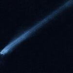 Une séquence de lumière blanche et mouchetée s'étend sur une image principalement noire. À une extrémité de la bande, la lumière se termine brusquement avec la suggestion de forme sombre et ronde.