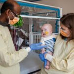 KJ after an infusion with researchers Rebecca Ahrens-Nicklas and Kiran Musunuru