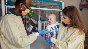 KJ after an infusion with researchers Rebecca Ahrens-Nicklas and Kiran Musunuru