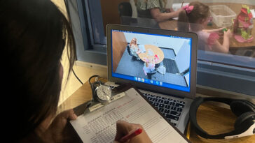 Un gestionnaire de cas observe un parent et un enfant à travers un miroir bidirectionnel lors d'une session de formation aux compétences comportementales.