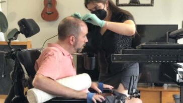 The man being connected to the brain-computer interface system