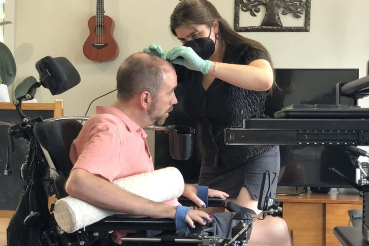 The man being connected to the brain-computer interface system