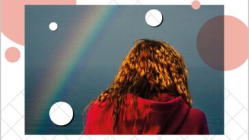 Rear view of woman wearing a red hoodie under a rainbow