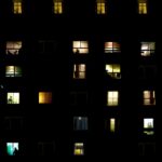 Block of flats Description Block of flats during night time with many figures in the windows and symmetrical staircase on both sides lit in green