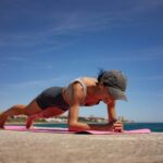 Brunette Woman Performing Isometric Exercises on Pink Exercise M; Shutterstock ID 2490925757; purchase_order: -; job: -; client: -; other: -