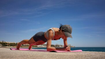 Brunette Woman Performing Isometric Exercises on Pink Exercise M; Shutterstock ID 2490925757; purchase_order: -; job: -; client: -; other: -