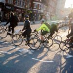 Cyclists and commuters make their ways home in evening sunshine at the junction of Fleet Street and Ludgate Hill in the City of London, aka the Square Mile - the capital