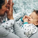 Mother holding baby on her lap and playing. Happy little boy looking at mother.; Shutterstock ID 1368345290; purchase_order: -; job: -; client: -; other: -