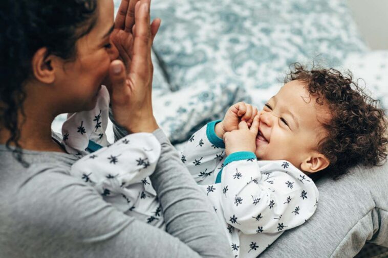 Mother holding baby on her lap and playing. Happy little boy looking at mother.; Shutterstock ID 1368345290; purchase_order: -; job: -; client: -; other: -