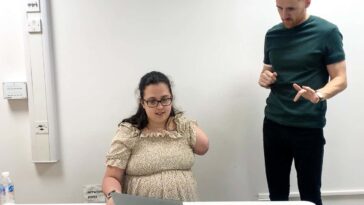 Trial participant Emily Wheldon with one of the researchers as she practiced attempting to move the lost fingers from her amputated arm before going into an MRI scanner