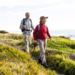 Senior couple (aged 65-69) hiking together on a coastal path