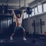 Bodybuilder exercising with barbells in the gym