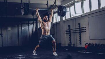 Bodybuilder exercising with barbells in the gym