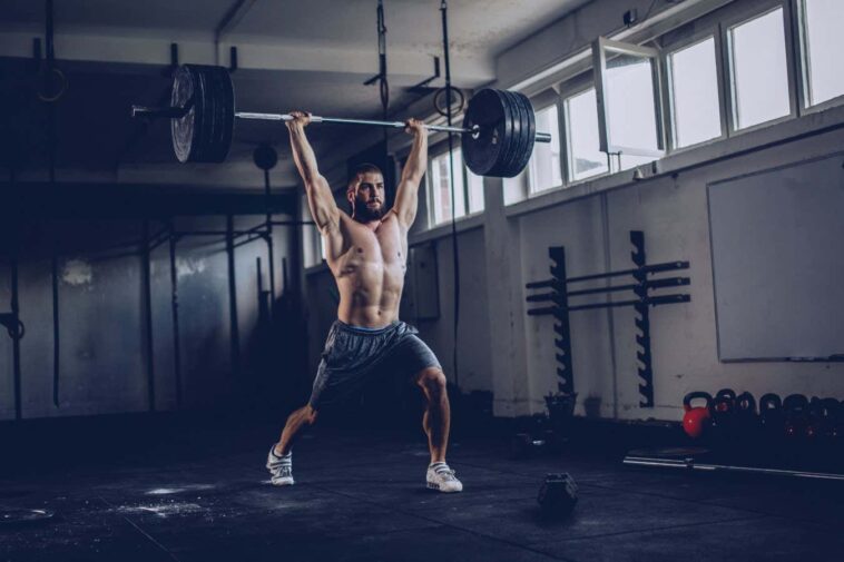 Bodybuilder exercising with barbells in the gym