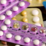 Oral contraceptive pill on pharmacy counter with colorful pills strips background.; Shutterstock ID 660070831; purchase_order: -; job: -; client: -; other: