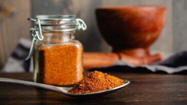 Spoonful of Homemade Berbere Spice Blend Close-up: Side view of East African spice mixture in a spoon with glass jar and mortar and pestle nearby; Shutterstock ID 2546039369; purchase_order: -; job: -; client: -; other: