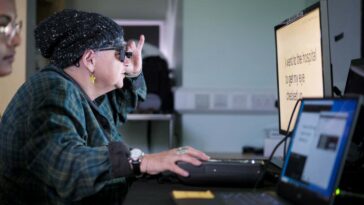 A study partipant wearing the glasses and testing her reading after being fit with the retinal implant