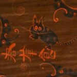 Un dessin sur un artefact comprend un dessin de ce qui ressemble à un chat noir avec des oreilles pointues et pelucheuses, des griffes pointues, des taches sur le dos et des rayures sur la queue.