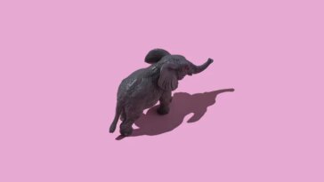 Un éléphant en jouet semble marcher sur un fond rose sur cette image prise d'en haut.