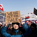 A protester holds a sign reading