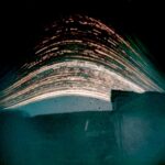 Janette Kerr PPRWA Hon. RSA, Twenty Solargraphs from the Solargraphic Project 2020-24 Formless 2024-25 (exposure time 18 months) Solargraph on paper Kerr collaborated with communities in Iceland, Greenland, Shetland and Somerset, to record the slow passage of time in different landscapes. The solargraphic process is a form of long-exposure photography. Kerr captures the arc of the Sun, as it moves across the sky from dawn to dusk, on photographic paper sealed in DIY pinhole cameras made from drinks cans. Her approach combines science and art, chemistry and the digital processing of the final image. Slow Time. The Sun rises and falls each day, its gradual trek discreetly recorded by small tin cans whose uninterrupted gaze captures every photon of sunlight travelling across the sky. Solargraphy (from the Latin solar, of the sun, and graphia, writing) is a form of long-exposure photography that captures the Sun moving across the sky. It combines science and art, chemistry and [today] digital elements. Being able to capture an extended period of time in a single frame, far beyond the capacity of the human eye, is incredible enough, but even more amazing is how simple it is. A low-tech process, solargraphy typically uses pinhole cameras made from used drinks cans. Sheets of black-and-white photographic paper can be sealed inside the cans, and then the cameras are fixed outdoors, facing south [in the Northern Hemisphere]. We usually think of photography as an instant process, images captured digitally in a fraction of a second. Solargraphs by Kerr have been recorded over a period of 1?18 months, mapping landscape in slow time. Light waves are captured as they travel through the air, passing through a pinhole in the side of the can and slowly etching an image on photographic paper curved around the inside. The resulting images are shaped by landscape and the Sun?s daily elevation. Actions of the environment ? rain and other elemental detritus, or the can?s unexpected movement ? also leave traces on the final pictures, yet moving objects leave no trace. Solargraphy is a ?printing-out? process: this is where an image forms on photographic paper solely through the action of light, without using chemicals to develop the image. Light provides the energy required for silver halides (salts) in the photographic paper to change to a visible state. When silver halides are exposed to light, free metallic silver atoms are ?liberated?, forming a latent image. Over a prolonged exposure of several months the silver halide particles clump together, increasing in size. The photographic paper slowly becomes coloured, transitioning from yellow to sepia and then pink, even slate grey. (In traditional photography, the latent image would be chemically developed in a darkroom.) For contemporary solargraphy, the image captured on the paper can be scanned and manipulated, using a photo-editing program on a laptop, to form a digital record. A solargraphic project was initiated by Kerr during various residencies, and in collaboration with communities in Iceland, Greenland, Shetland and Somerset. The final images that she produces show the Sun?s progress as an accumulation of arcing and streaking lines, leaving ghostly exposures of landscape seen in slow time, out of phase with human activity. w3w: ///reporters.survived.formless (Coleford, Somerset) 2024?5 Solargraph on paper (exposure time: 18 months) 21 x 30cm COURTESY OF THE ARTIST