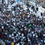Des centaines de personnes brandissaient des pancartes de protestation dans une rue de Minneapolis.