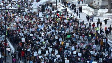 Des centaines de personnes brandissaient des pancartes de protestation dans une rue de Minneapolis.