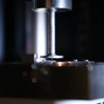 Une petite balle plane dans l’ouverture étroite d’une machine qui ressemble à une petite presse