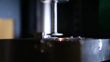 Une petite balle plane dans l’ouverture étroite d’une machine qui ressemble à une petite presse