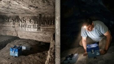 Un chercheur à l'intérieur d'une chambre sombre de la Grande Pyramide d'Égypte porte une lampe frontale et regarde une boîte bleue, avec une deuxième boîte grise à proximité - un équipement utilisé pour mesurer les vibrations à l'intérieur de la pyramide.
