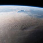 Une image de la Terre prise depuis l'espace montre un panache grisâtre couvrant une grande partie du globe.