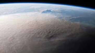 Une image de la Terre prise depuis l'espace montre un panache grisâtre couvrant une grande partie du globe.