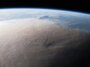 Une image de la Terre prise depuis l'espace montre un panache grisâtre couvrant une grande partie du globe.