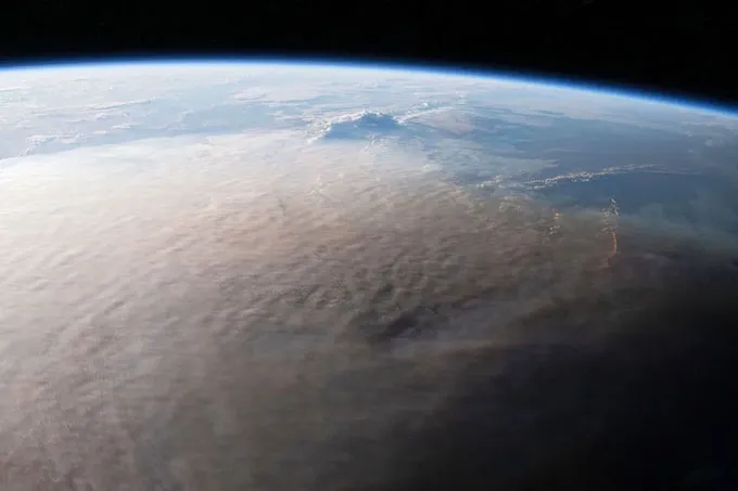 Une énorme éruption volcanique offre des indices pour lutter contre le changement climatique Une image de la Terre prise depuis l'espace montre un panache grisâtre couvrant une grande partie du globe.